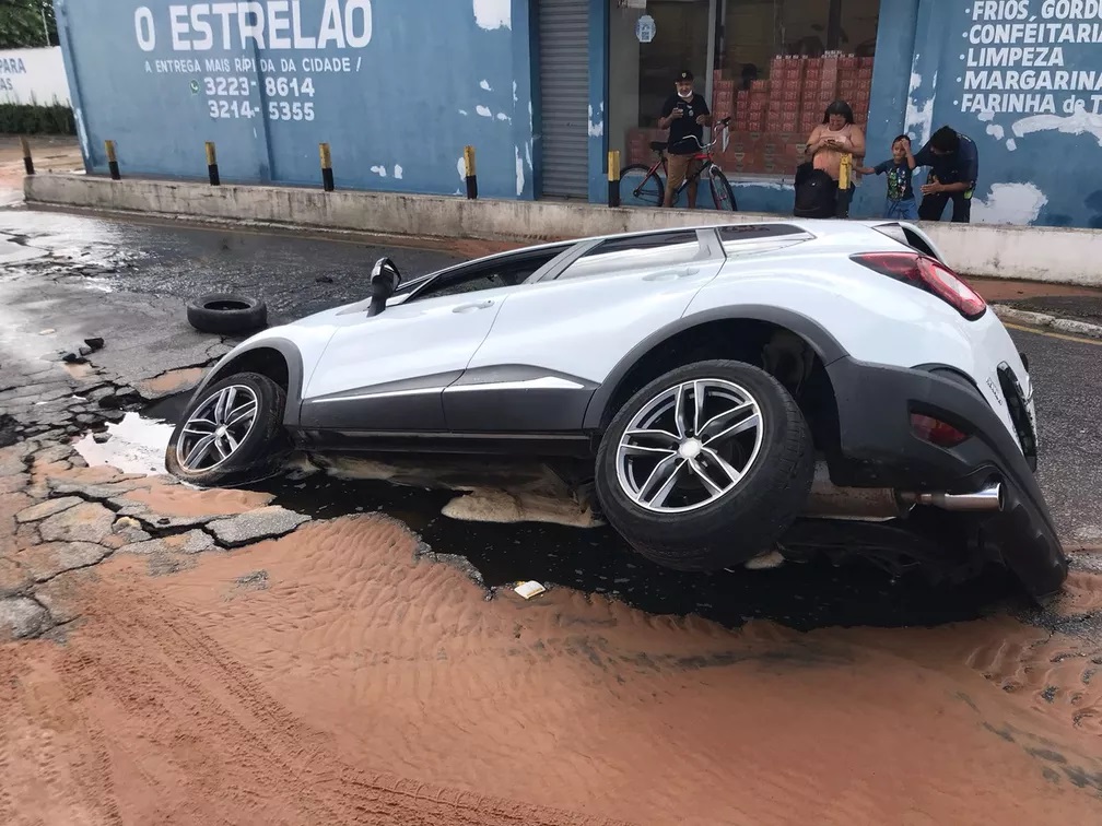 Motorista afunda carro em cratera após pensar ser uma pequena poça poça d’água; veja vídeo