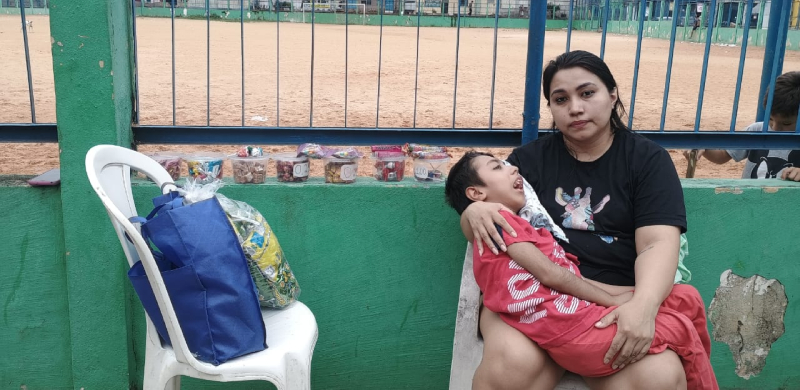 Mãe de vítima de falsa médica em Manaus vende bombons para comprar carrinho adaptado; saiba como ajudar